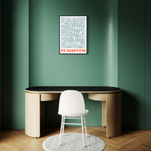 Load image into Gallery viewer, A framed street map print of De Beauvoir Town, London, hangs on a dark green wall above a modern beige desk and white chair in a minimalist room.